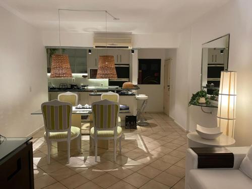 una cucina e un soggiorno con tavolo e sedie di BEIRA DA PRAIA com VISTA TOTAL DO MAR a Florianópolis