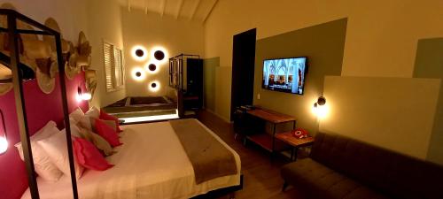 a bedroom with a bed and a flat screen tv at Pousada Toca da Praia in Maresias