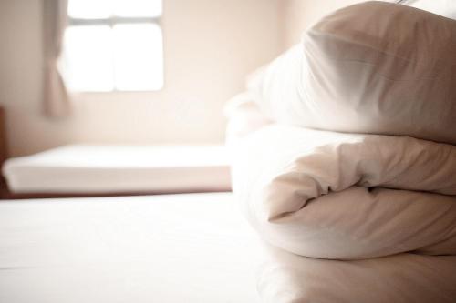 a white pillow sitting on top of a bed at New May Flower Hotel in Taipei