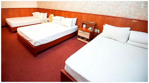 a hotel room with two beds and two tables at New May Flower Hotel in Taipei