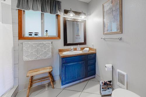 a bathroom with a blue sink and a mirror at Ottertail Cabin in Joseph