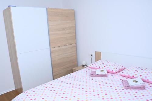 a bedroom with a bed with pink polka dots at Apartments Mak in Moravske Toplice