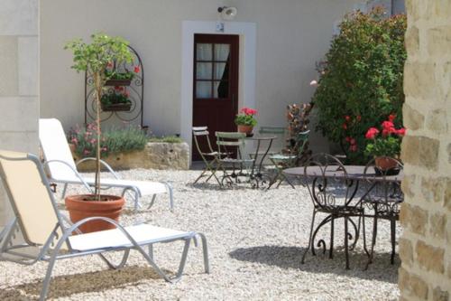 a group of chairs and tables in a courtyard at Chambres et table d'hôtes Saint Nicolas, maisonnettes individuelles dans propriété privée in Vézinnes