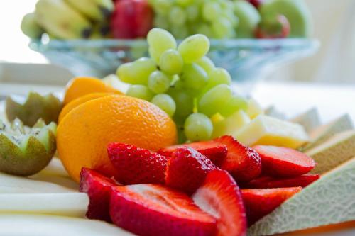 a pile of fruit on a plate with grapes and strawberries at Altstadthotel Zur Börse in Goslar