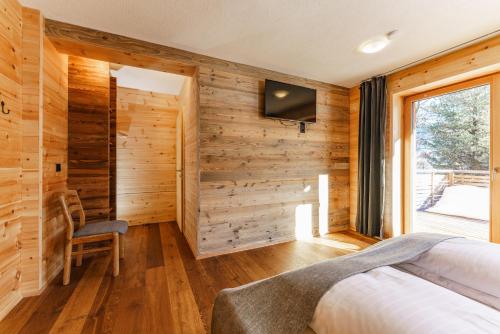a bedroom with wooden walls and a bed and a window at Biochalet-Ebenbauer in Schladming