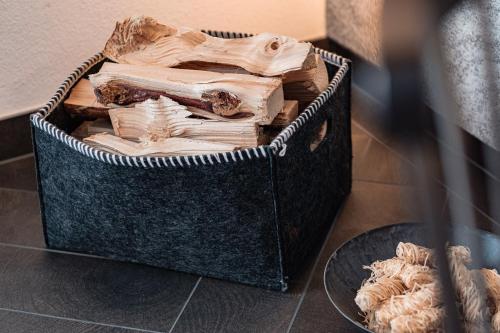 a basket full of wood sitting on a table at APART HERZOG - URBAN LUXURY LIFESTYLE direct at Steinbergpiste and Steinbergbahn in Leogang