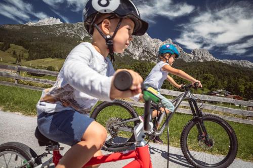 a woman and a child riding a bike at APART HERZOG - URBAN LUXURY LIFESTYLE direct at Steinbergpiste and Steinbergbahn in Leogang