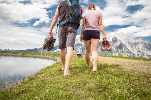 a man and woman walking down a path next to a lake at APART HERZOG - URBAN LUXURY LIFESTYLE direct at Steinbergpiste and Steinbergbahn in Leogang
