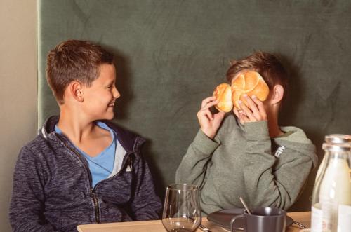 two young boys sitting at a table eating food at APART HERZOG - URBAN LUXURY LIFESTYLE direct at Steinbergpiste and Steinbergbahn in Leogang