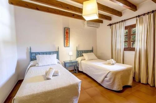 1 dormitorio con 2 camas en una habitación con ventana en Villa Panada, en Pollensa
