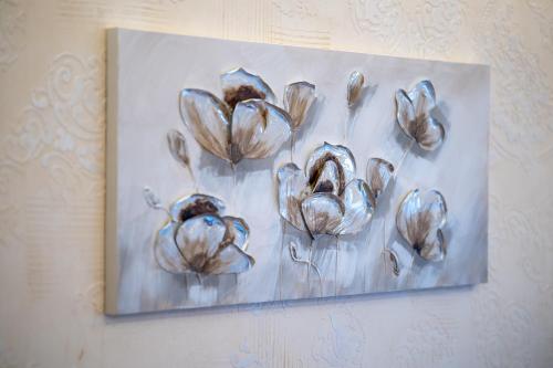 a painting of flowers hanging on a wall at Apartman Lux M&B in Zlatibor