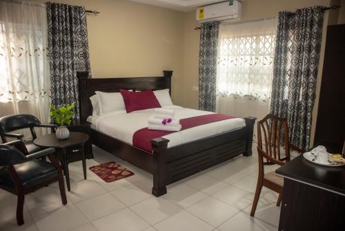 Kislas Luxury Hotel في Pantang: غرفة نوم بسرير وطاولة وكراسي