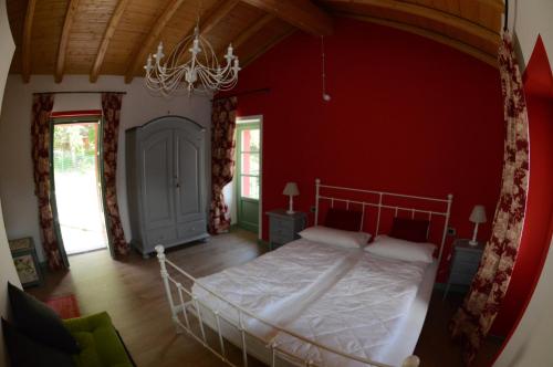 a bedroom with a bed in a red wall at Tuschaus in Domaso