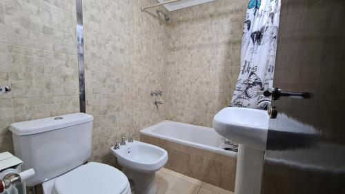 ein Badezimmer mit einem WC, einem Waschbecken und einer Badewanne in der Unterkunft Amplio y Cómodo Depto. 6 Personas in Salta