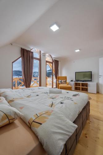 a large bed in a room with a large window at Idila Zaovinskog jezera in Zaovine