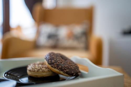 two donuts sitting on a plate in a box at Idila Zaovinskog jezera in Zaovine