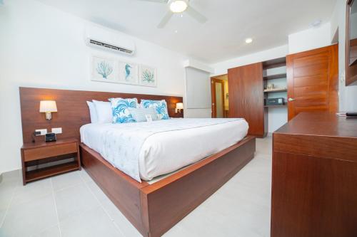 a bedroom with a large bed with a wooden headboard at Presidential Suites Cabarete - Room Only in Cabarete