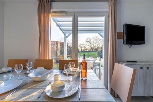 - une table à manger avec une bouteille de vin dans l'établissement Maison avec terrasse pour 6 à Talmont St-Hilaire, à Saint-Hilaire-de-Talmont