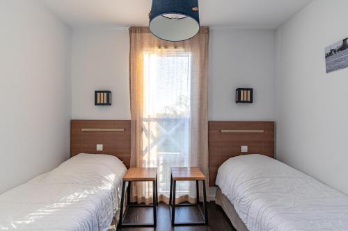 deux lits dans une chambre avec une fenêtre dans l'établissement Maison avec terrasse pour 6 à Talmont St-Hilaire, à Saint-Hilaire-de-Talmont
