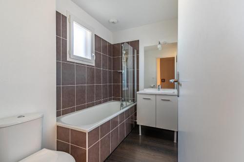 une salle de bain avec une baignoire, des toilettes et un lavabo dans l'établissement Maison avec terrasse pour 6 à Talmont St-Hilaire, à Saint-Hilaire-de-Talmont