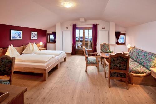 APARTMENT SONNBLICK Kaprun Salzburg - incl Zell am See-Kaprun Summercard في كابرون: غرفة نوم بسرير واريكة وطاولة