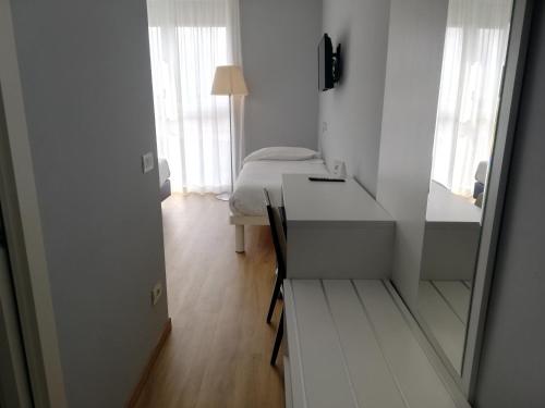 a white room with a bed and a desk and a mirror at Novo Hotel Rossi in Verona