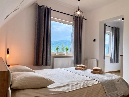 a bedroom with two towels on a bed with a window at Apartamenty Jelonek Zakopane in Zakopane