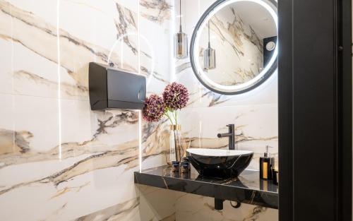 a bathroom with a sink and a mirror at Wrota Chałubińskiego in Zakopane