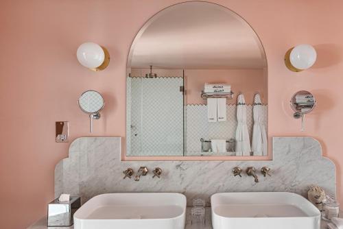 a bathroom with two sinks and a mirror at The Henrietta Hotel in London