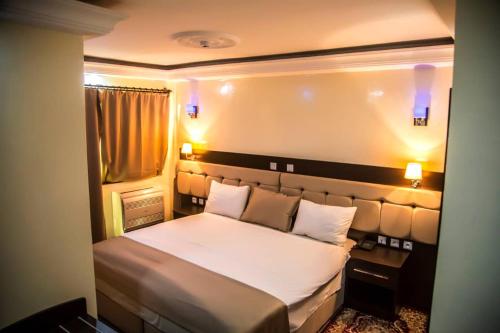 a bedroom with a large white bed with two pillows at Hotel Univers 3 Aeroport Luxe in Niamey