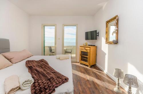 una camera con letto, specchio e TV di Apartments Daniela Della a Novalja (Novaglia)