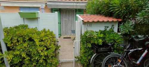 una bicicleta estacionada frente a una valla blanca en Studio avec terrasse à 300m de la plage, en Fleury