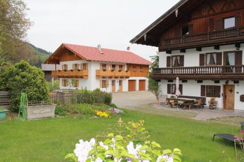 ein großes Haus mit einem Hof und einem Haus mit Blumen in der Unterkunft MoarHof Feilnbach in Bad Feilnbach