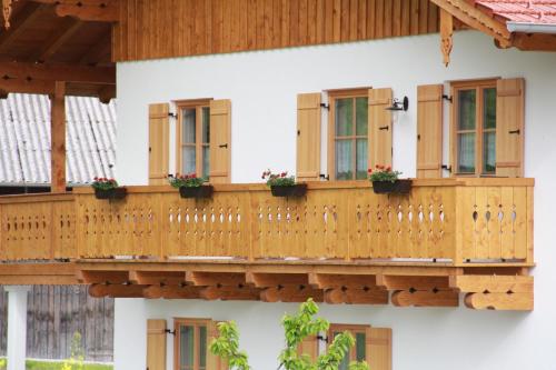 uma casa com uma varanda de madeira com janelas em MoarHof Feilnbach em Bad Feilnbach