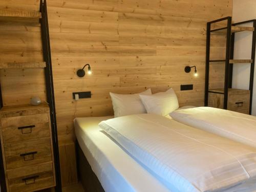 2 Betten in einem Schlafzimmer mit Holzwänden in der Unterkunft Alpenflair Ferienwohnung 231 Mina's Gipfelliebe in Oberstdorf