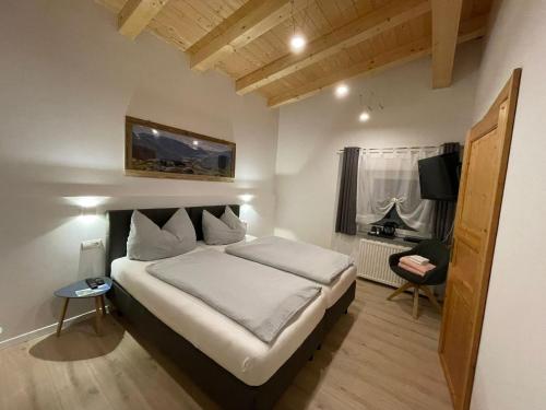 1 dormitorio con 1 cama grande y escritorio en Zimmer bei Landhaus Mayr en Maurach