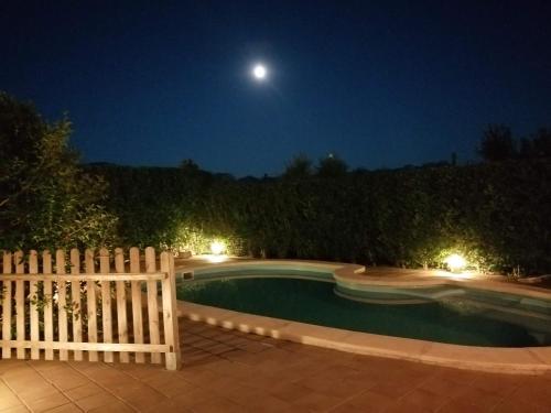 a pool at night with a fence and the moon at Font Major in Horta de San Joan