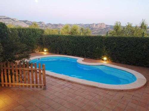 a swimming pool with a wooden fence in a yard at Font Major in Horta de San Joan