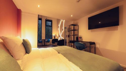 a bedroom with a bed and a desk and a television at Oldschool Hotel in Winterswijk