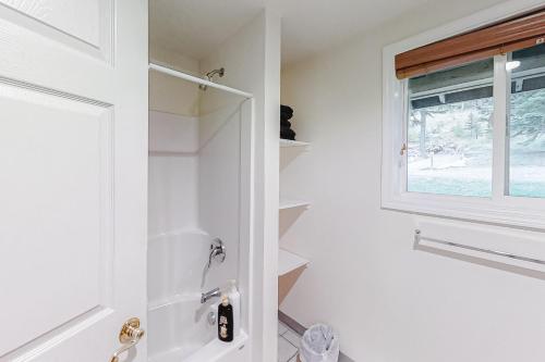 a white bathroom with a shower and a window at Glacier Lake in Joseph