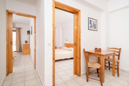 a room with a table and a bedroom with a bed at Adonis Hotel in Agia Galini