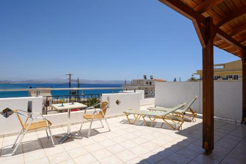 a patio with chairs and tables on a roof at Adonis Hotel in Agia Galini