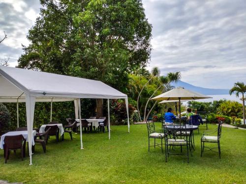a group of tables and chairs under a white tent at Hotel San Buenaventura de Atitlán in Panajachel