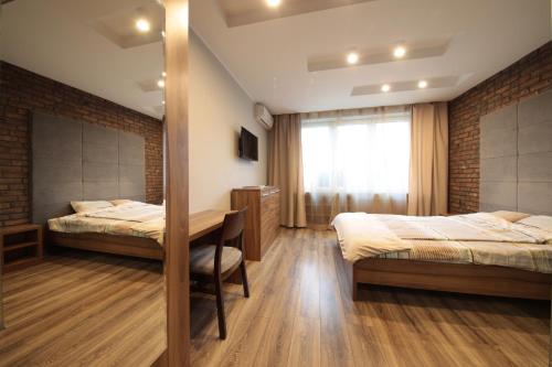 ビャウィストクにあるAPARTVIP Grochowaのベッド2台と机と窓のある寝室
