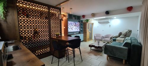 a living room with a tv and a table and chairs at סוויטת נור Noor Suite in Majdal Shams