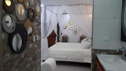 1 dormitorio con cama blanca y lavamanos en Hotel SARALI, en Doradal