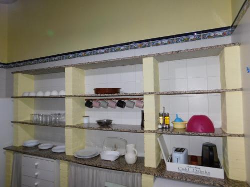 een plank in een keuken met servies en keukengerei bij La Silla de la Reina in Navarredonda de Gredos