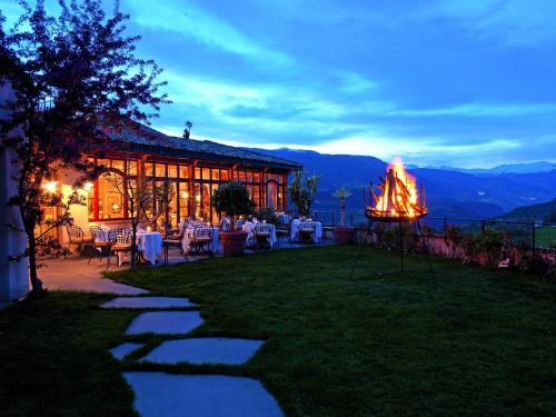 a restaurant with a table and chairs in the grass at Romantik Hotel Turm in Völs am Schlern
