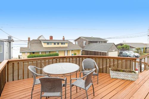 a patio with a table and chairs on a deck at Cozze Cottage in Wecoma Beach