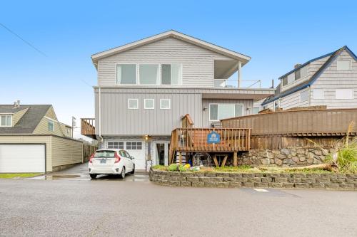 a house with a car parked in a driveway at Cozze Cottage in Wecoma Beach